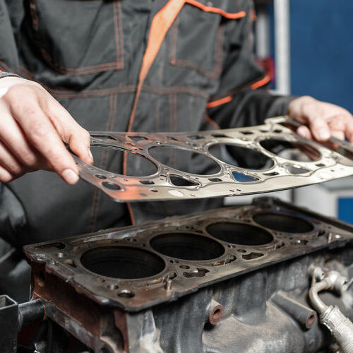 The mechanic disassemble block engine vehicle. Engine on a repair stand with piston and connecting rod of automotive technology. Interior of a car repair shop